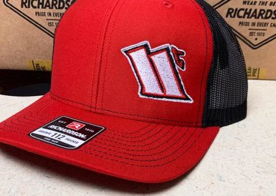 Image of red cap with 11t embroidered on the front left side.
