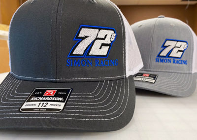 Photo of 72S Simon Racing logo embroidered on two hats.