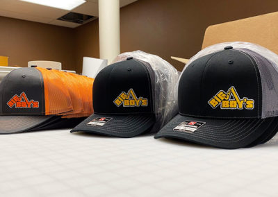 Photo showing multiples hats with Big Boy's logo embroidery