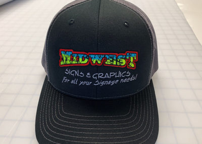 Image showing the Midwest Signs and Graphics logo embroidered on a black hat.