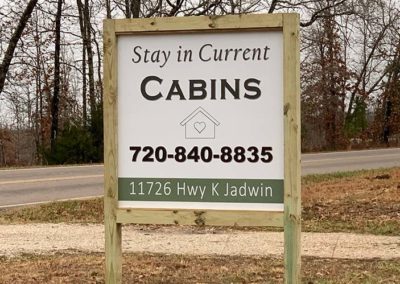 Image of an outdoor sign with information about Current Cabins