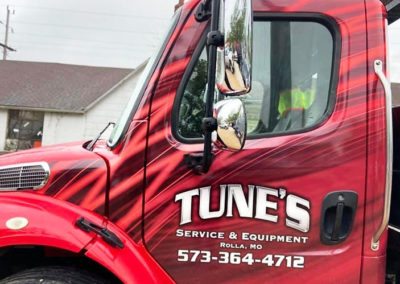 Image showing a partial vehicle wrap for Tune's Service and Equipment.