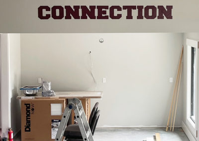 Image of an interior wall with the word "Connection" in vinyl lettering.