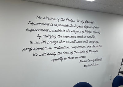 Picture of an interior wall with the mission statement of the Phelps County Sheriff's Department displayed in vinyl lettering.